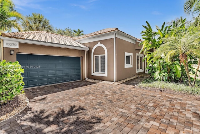 10370 NW 11th St, Plantation, FL 33322 - mediterranean / spanish home with decorative driveway, an attached garage, stucco siding, and a tiled roof