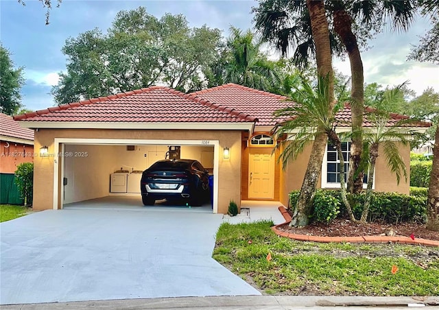 1084 Aspri Way, Riviera Beach, FL 33418 - mediterranean / spanish-style home featuring stucco siding, driveway, washer / dryer, and an attached garage