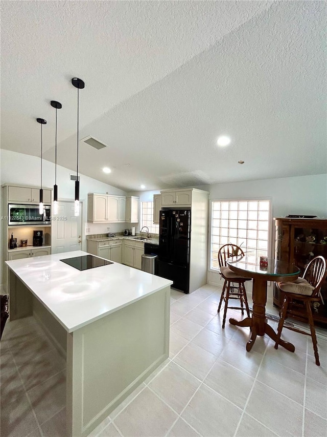 1084 Aspri Way, Riviera Beach, FL 33418 - kitchen with black appliances, a textured ceiling, a kitchen island, light countertops, and hanging light fixtures
