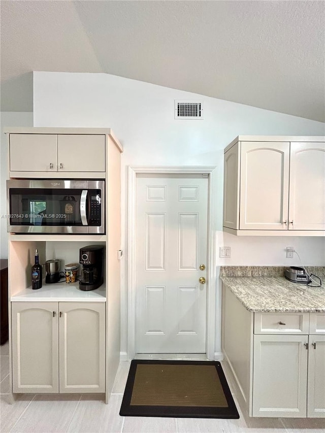 1084 Aspri Way, Riviera Beach, FL 33418 - interior space with lofted ceiling and stainless steel microwave