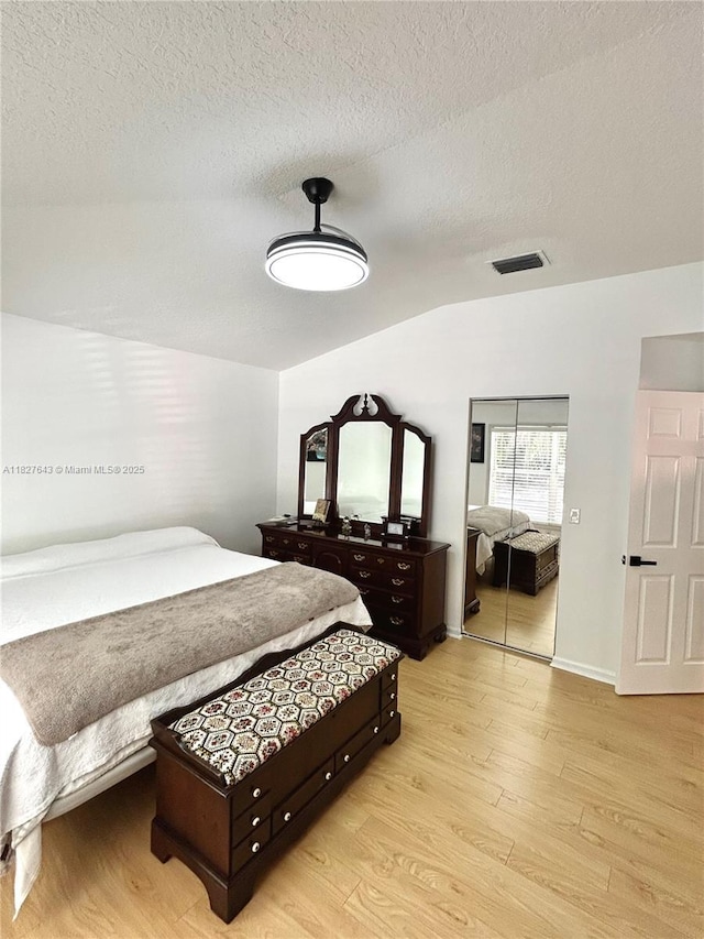 1084 Aspri Way, Riviera Beach, FL 33418 - bedroom featuring light wood-type flooring, lofted ceiling, and a textured ceiling