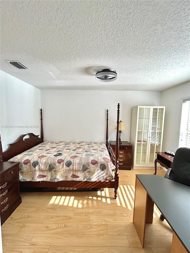 1084 Aspri Way, Riviera Beach, FL 33418 - bedroom featuring light wood-style flooring and a textured ceiling