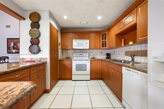 5143 SW 142nd Pl, Miami, FL 33175 - kitchen with white appliances, brown cabinetry, decorative backsplash, stone countertops, and a textured ceiling