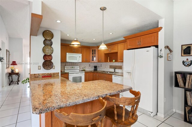 5143 SW 142nd Pl, Miami, FL 33175 - kitchen featuring white appliances, a peninsula, light tile patterned flooring, light stone counters, and tasteful backsplash