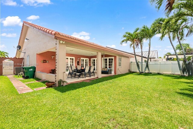 5143 SW 142nd Pl, Miami, FL 33175 - back of house featuring stucco siding, a gate, a patio area, a tile roof, and french doors