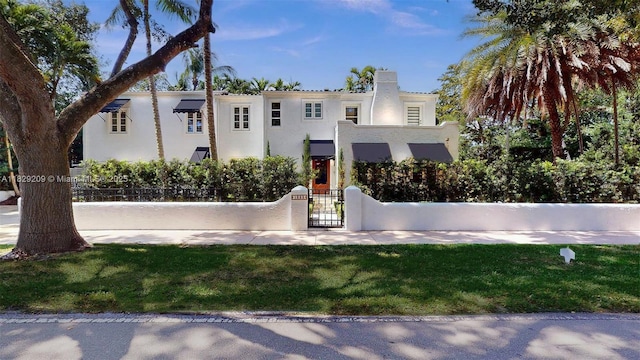 1222 Cortez St, Coral Gables, FL 33134 - mediterranean / spanish house with a fenced front yard, a gate, and stucco siding