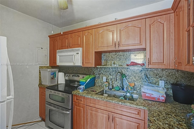 100 SW 67th Ct, Miami, FL 33144 - kitchen with white appliances, decorative backsplash, dark stone counters, light tile patterned flooring, and brown cabinets