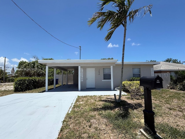 1494 W 34th St, Riviera Beach, FL 33404 - view of front of house with concrete driveway, an attached carport, and stucco siding