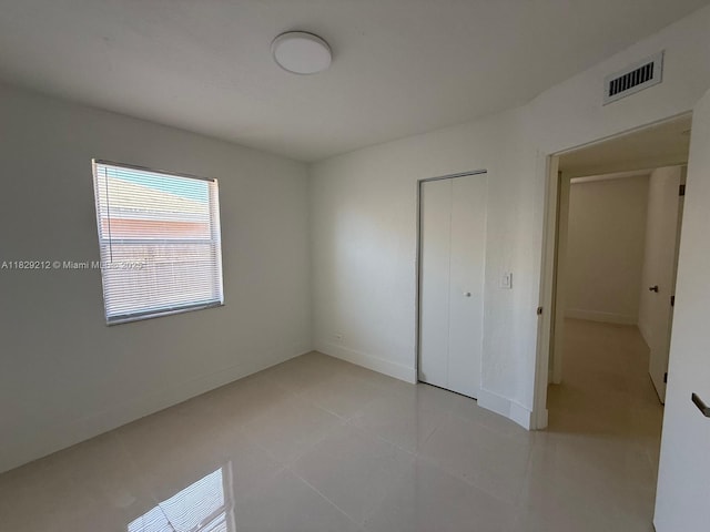1494 W 34th St, Riviera Beach, FL 33404 - unfurnished bedroom with a closet and light tile patterned floors