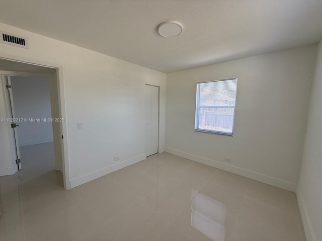 1494 W 34th St, Riviera Beach, FL 33404 - unfurnished bedroom with a closet and light tile patterned floors