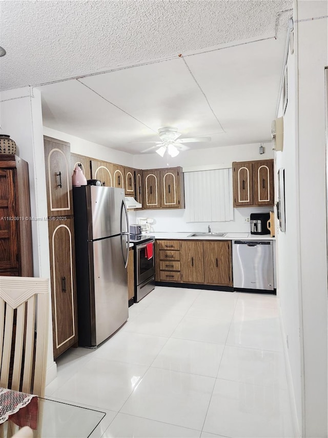 2541 Aragon Blvd Unit 105, Sunrise, FL 33322 - kitchen featuring appliances with stainless steel finishes, exhaust hood, ceiling fan, light countertops, and light tile patterned floors