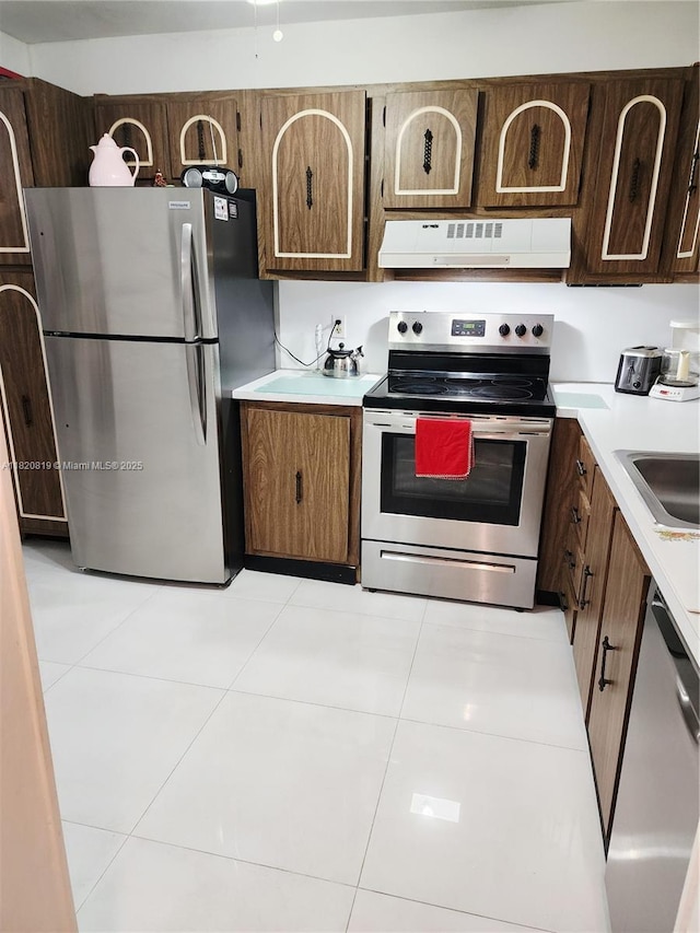 2541 Aragon Blvd Unit 105, Sunrise, FL 33322 - kitchen featuring appliances with stainless steel finishes, ventilation hood, light countertops, and light tile patterned floors