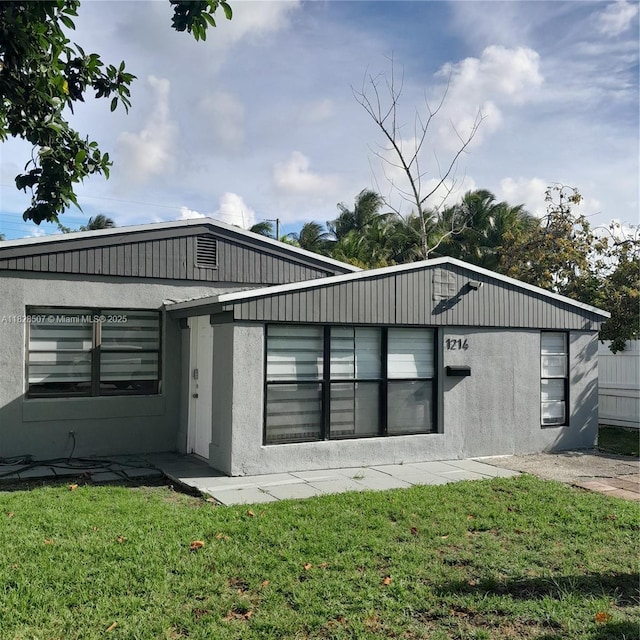 1214 NE 180th St, North Miami Beach, FL 33162 - view of front of house featuring a front yard and stucco siding