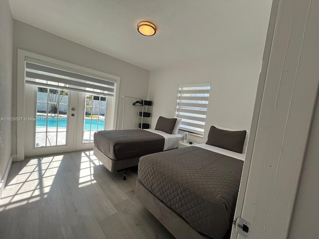 1214 NE 180th St, North Miami Beach, FL 33162 - bedroom featuring french doors, multiple windows, access to exterior, and wood finished floors