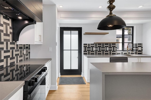 1145 SW 20th Ave, Miami, FL 33135 - kitchen featuring black / electric stove, tasteful backsplash, light wood-style floors, white cabinetry, and recessed lighting
