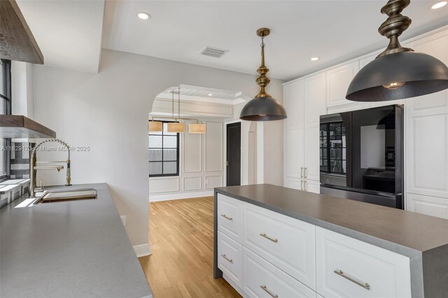 1145 SW 20th Ave, Miami, FL 33135 - kitchen with refrigerator, light wood-style flooring, recessed lighting, dark countertops, and white cabinets
