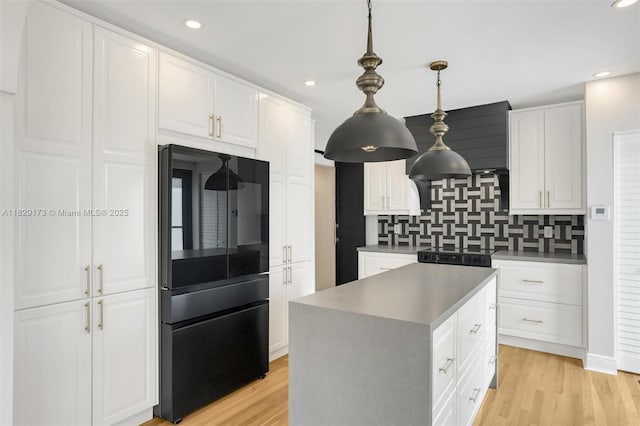 1145 SW 20th Ave, Miami, FL 33135 - kitchen featuring freestanding refrigerator, decorative backsplash, white cabinets, light wood-type flooring, and recessed lighting