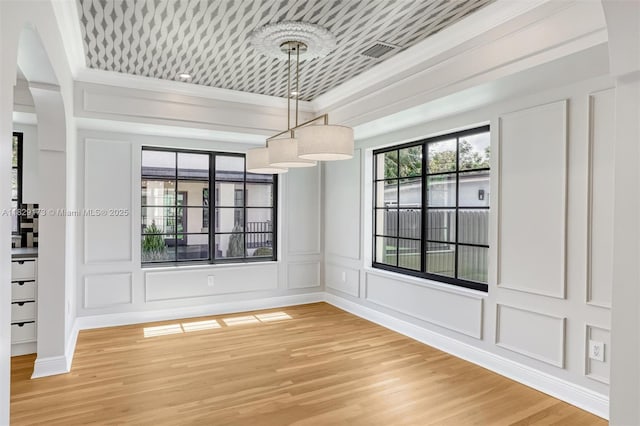 1145 SW 20th Ave, Miami, FL 33135 - unfurnished dining area featuring a decorative wall, ornamental molding, light wood-type flooring, and arched walkways