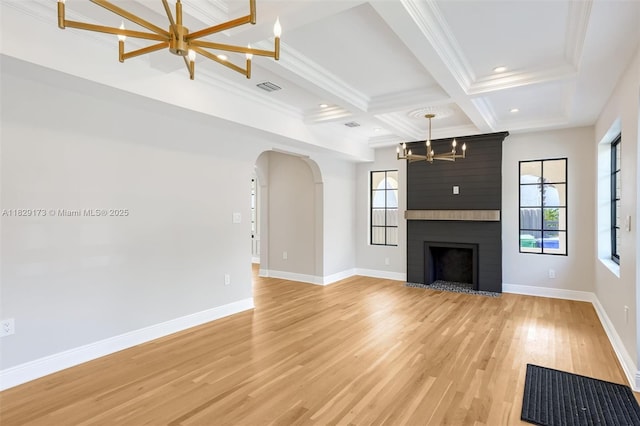 1145 SW 20th Ave, Miami, FL 33135 - unfurnished living room featuring a chandelier, coffered ceiling, arched walkways, light wood-style flooring, and beam ceiling