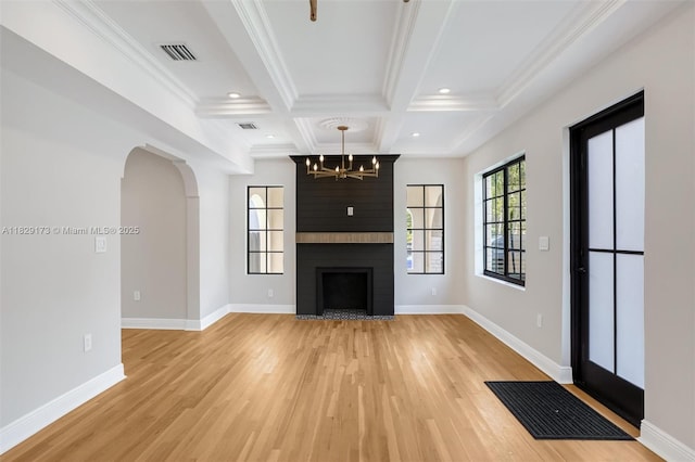 1145 SW 20th Ave, Miami, FL 33135 - unfurnished living room with light wood-style flooring, coffered ceiling, a chandelier, crown molding, and arched walkways