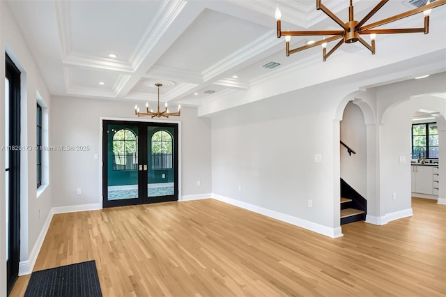 1145 SW 20th Ave, Miami, FL 33135 - spare room featuring a chandelier, light wood-style floors, arched walkways, stairway, and beam ceiling