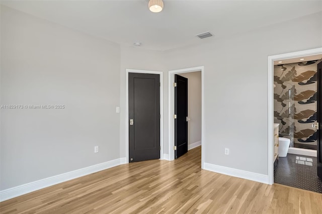 1145 SW 20th Ave, Miami, FL 33135 - unfurnished bedroom with a walk in closet, light wood-style flooring, and a closet