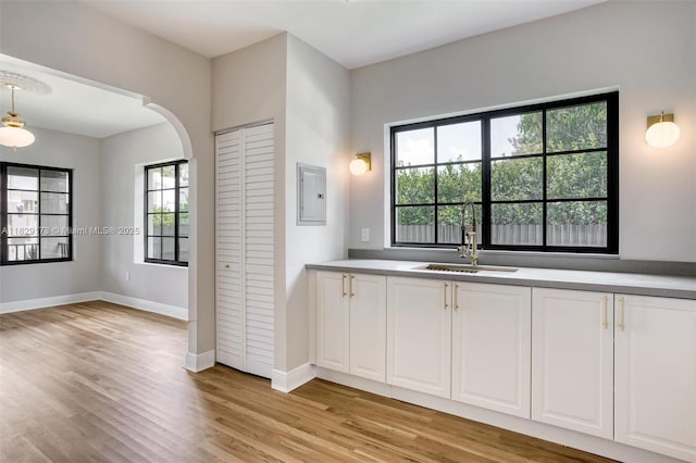 1145 SW 20th Ave, Miami, FL 33135 - kitchen with arched walkways, light wood-type flooring, plenty of natural light, and white cabinetry