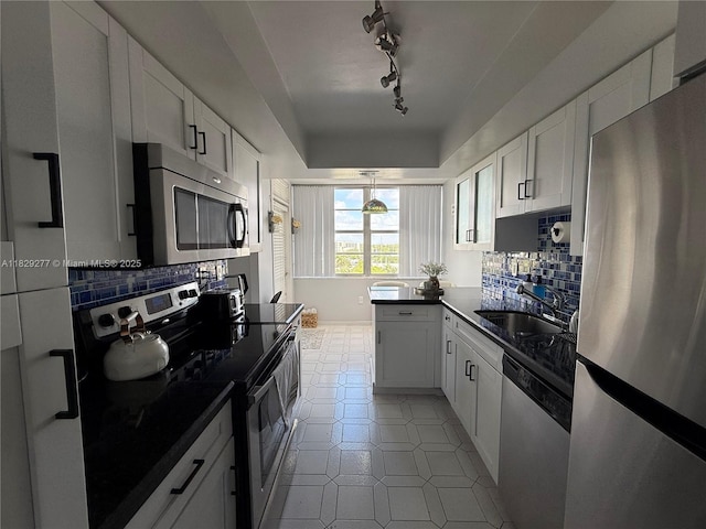 18011 Biscayne Blvd Unit 805, Aventura, FL 33160 - kitchen with appliances with stainless steel finishes, dark countertops, white cabinetry, light tile patterned floors, and backsplash