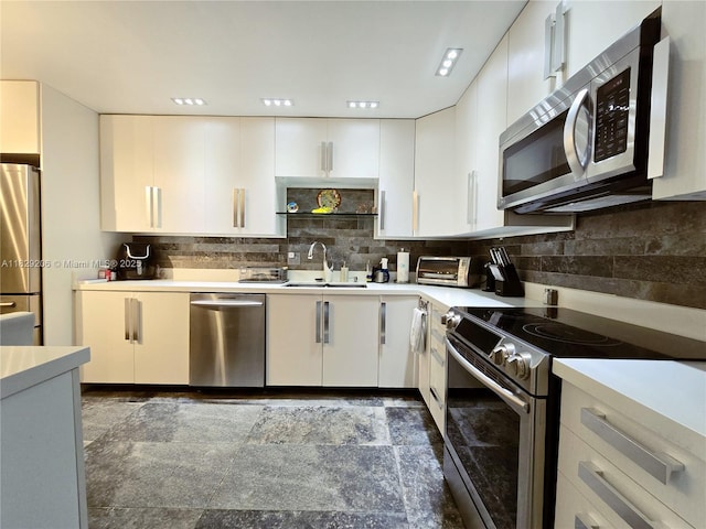 3071 N Course Dr Unit 107, Pompano Beach, FL 33069 - kitchen featuring appliances with stainless steel finishes, light countertops, white cabinetry, and tasteful backsplash