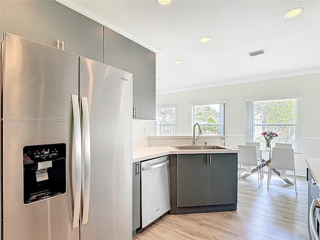 1568 SE 20th Ter, Homestead, FL 33035 - kitchen with stainless steel appliances, gray cabinetry, crown molding, a peninsula, and light wood-style flooring