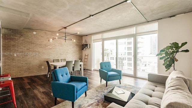 3250 NE 1st Ave Unit 1101, Miami, FL 33137 - living area featuring brick wall, healthy amount of natural light, a chandelier, and wood finished floors