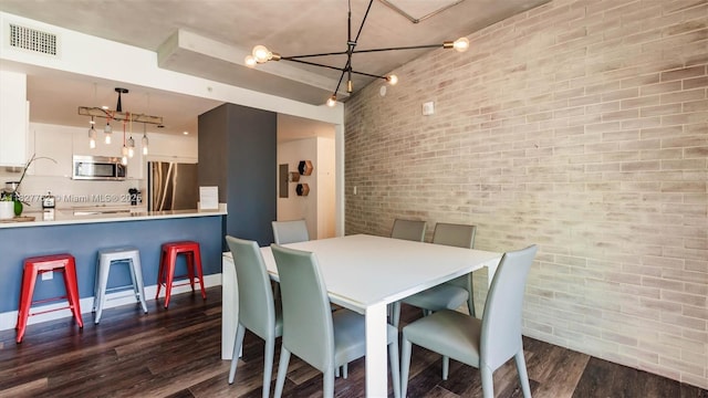 3250 NE 1st Ave Unit 1101, Miami, FL 33137 - dining area with brick wall, dark wood finished floors, and a chandelier