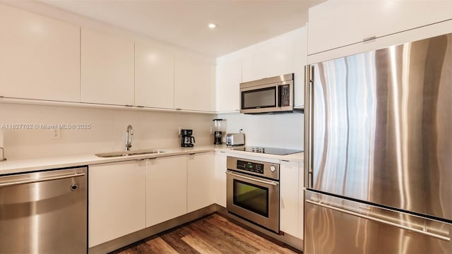 3250 NE 1st Ave Unit 1101, Miami, FL 33137 - kitchen with stainless steel appliances, light countertops, dark wood-type flooring, white cabinets, and modern cabinets