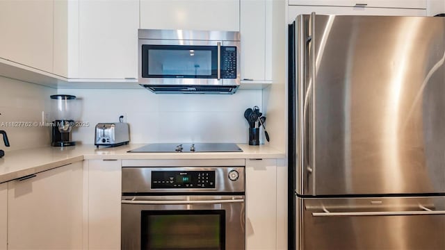 3250 NE 1st Ave Unit 1101, Miami, FL 33137 - kitchen with appliances with stainless steel finishes, white cabinets, modern cabinets, light countertops, and backsplash