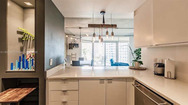 3250 NE 1st Ave Unit 1101, Miami, FL 33137 - kitchen with stainless steel dishwasher, a chandelier, light countertops, white cabinetry, and a peninsula