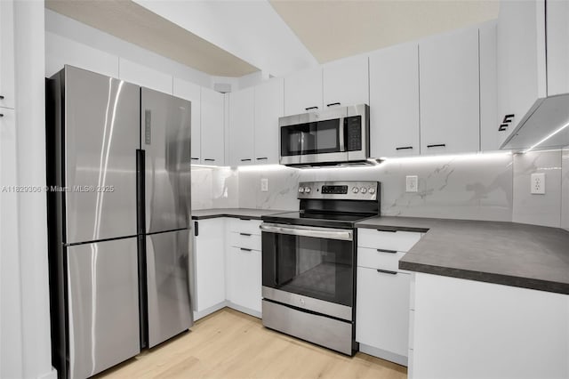 1611 Palermo Dr, Weston, FL 33327 - kitchen featuring appliances with stainless steel finishes, dark countertops, light wood-style flooring, white cabinets, and backsplash