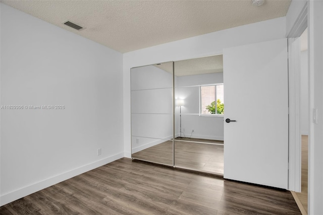 1611 Palermo Dr, Weston, FL 33327 - unfurnished bedroom with wood finished floors, a textured ceiling, and a closet