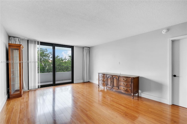 600 Three Islands Blvd Unit 310, Hallandale Beach, FL 33009 - unfurnished living room with a textured ceiling and light wood-style floors