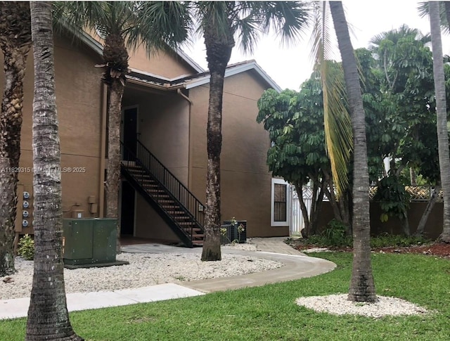 10670 SW 156th Pl Unit 309, Miami, FL 33196 - rear view of property with stucco siding, stairs, and a lawn