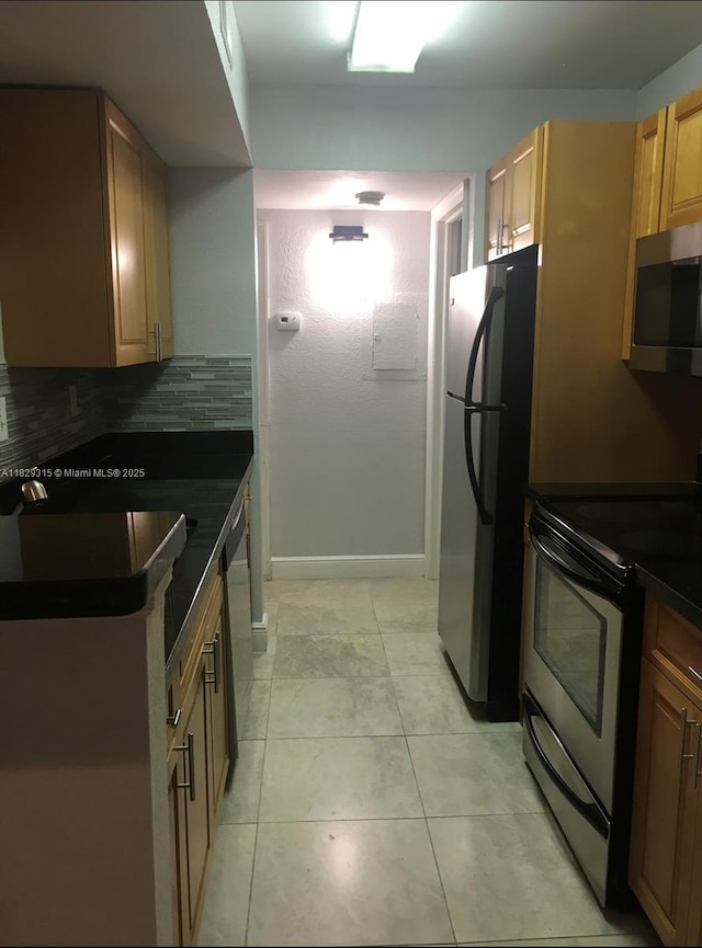 10670 SW 156th Pl Unit 309, Miami, FL 33196 - kitchen with appliances with stainless steel finishes, dark countertops, backsplash, and light tile patterned flooring