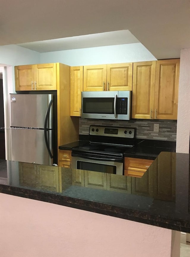 10670 SW 156th Pl Unit 309, Miami, FL 33196 - kitchen featuring appliances with stainless steel finishes, backsplash, dark stone countertops, and light brown cabinets