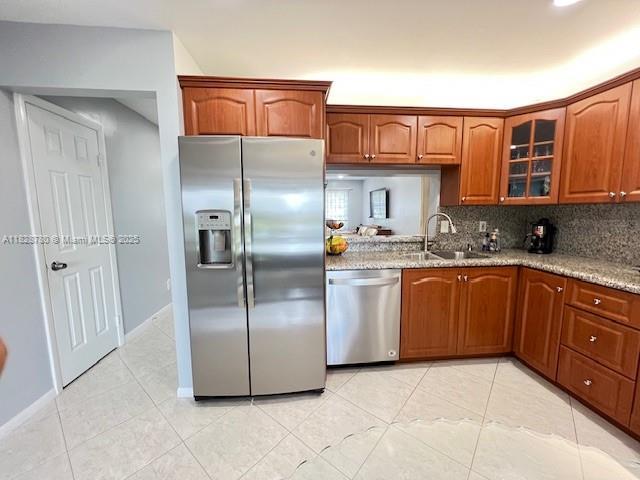 905 NW 107th Ave, Pembroke Pines, FL 33026 - kitchen with stainless steel appliances, glass insert cabinets, light tile patterned floors, and backsplash