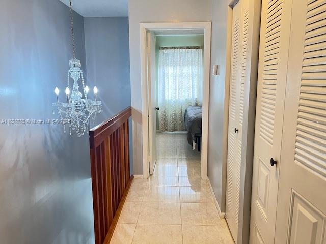 905 NW 107th Ave, Pembroke Pines, FL 33026 - hallway with a chandelier and light tile patterned flooring