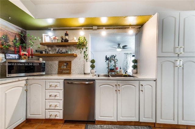 8065 W 14th Ct, Hialeah, FL 33014 - kitchen featuring stainless steel appliances, a ceiling fan, light countertops, rail lighting, and white cabinetry