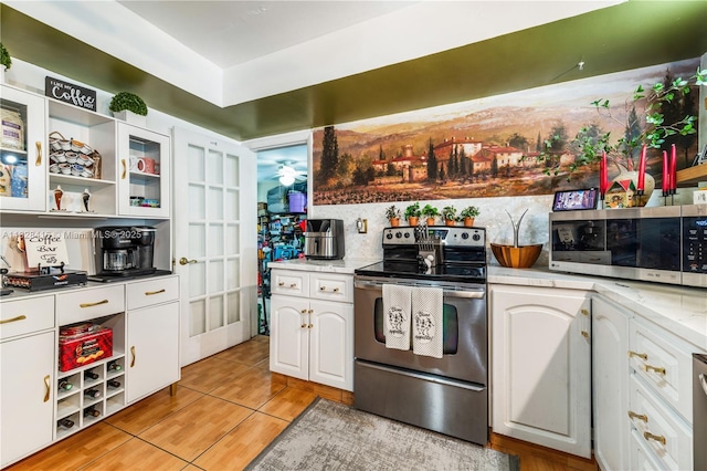 8065 W 14th Ct, Hialeah, FL 33014 - kitchen with appliances with stainless steel finishes, white cabinets, light tile patterned floors, light countertops, and open shelves