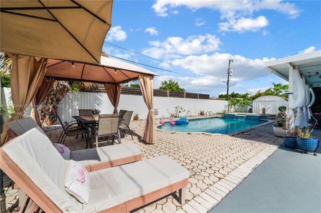 8065 W 14th Ct, Hialeah, FL 33014 - view of pool featuring a gazebo, a patio area, a fenced backyard, and a pool with connected hot tub