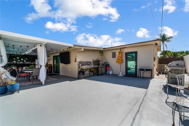 8065 W 14th Ct, Hialeah, FL 33014 - back of house featuring a patio, stucco siding, and outdoor dining area