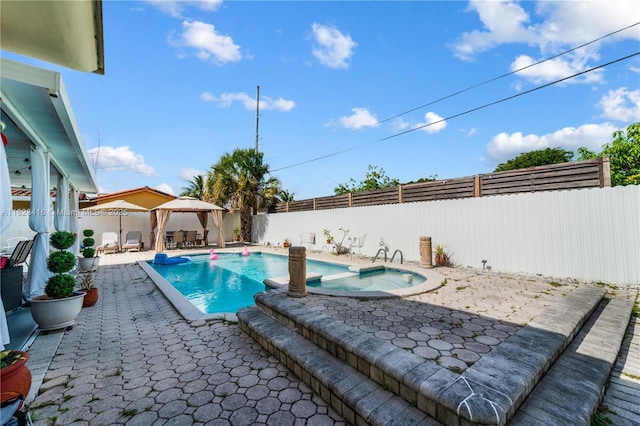 8065 W 14th Ct, Hialeah, FL 33014 - view of swimming pool with a gazebo, a patio, a fenced backyard, and a pool with connected hot tub