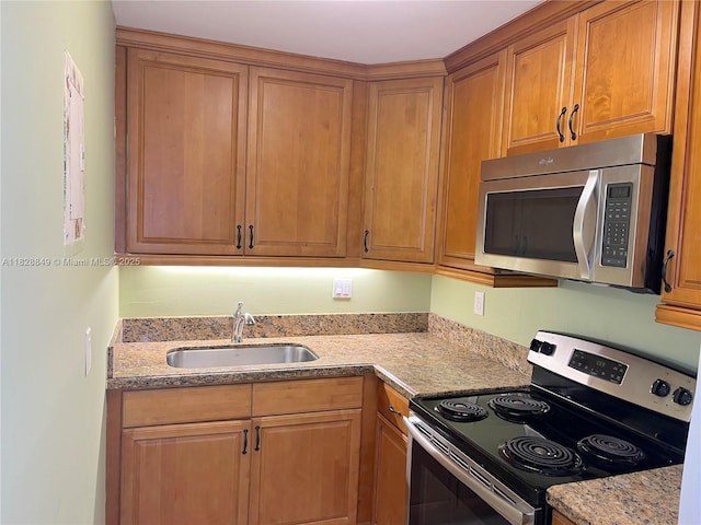 900 NE 18th Ave Unit 304, Fort Lauderdale, FL 33304 - kitchen with appliances with stainless steel finishes, brown cabinetry, and light stone countertops