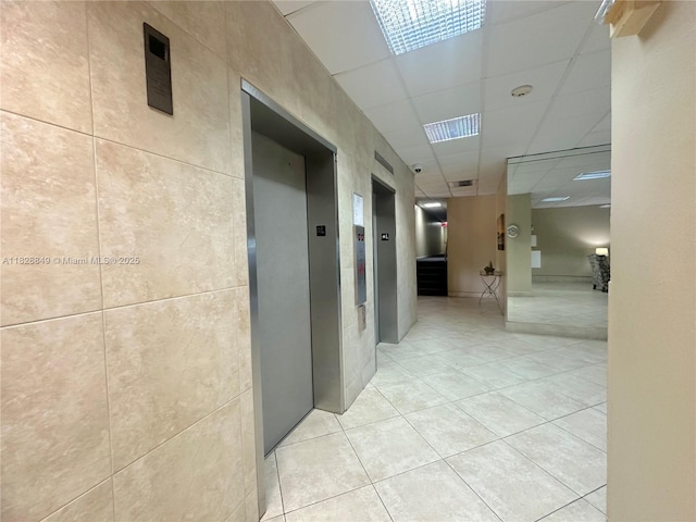 900 NE 18th Ave Unit 304, Fort Lauderdale, FL 33304 - corridor featuring a drop ceiling, light tile patterned floors, elevator, and stairs